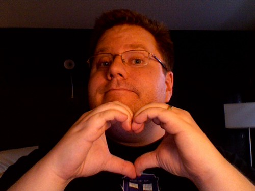 Kevin Lawver making a heart with his hands in a very cheesy self-portrait photo.