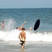 A guy flying off his skimboard