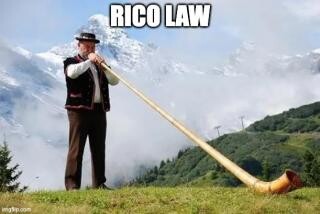 Man blowing a long horn in the mountains text is Rico law