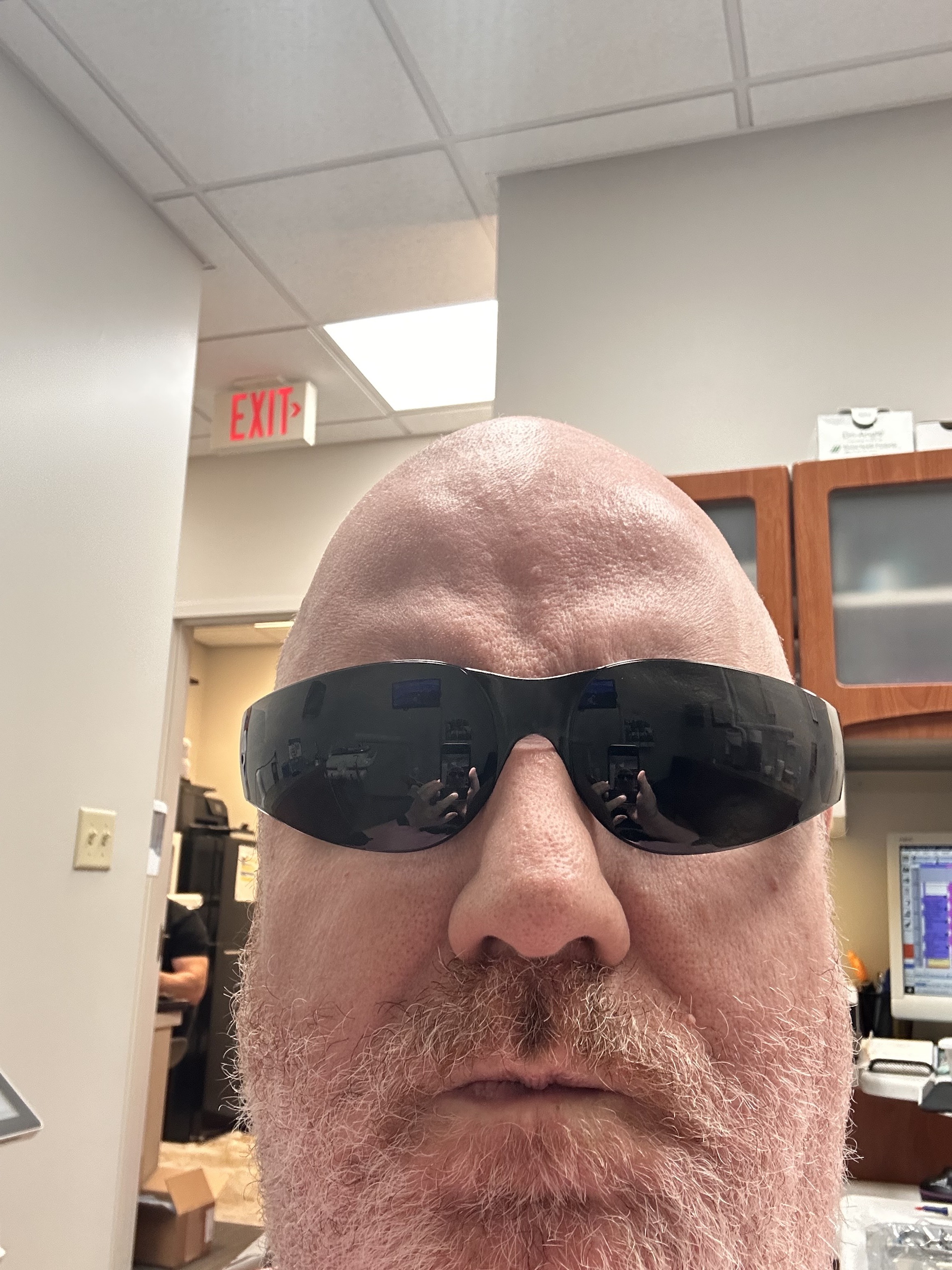 A self portrait of a bald middle aged man in silly sunglasses at the dentist office. 