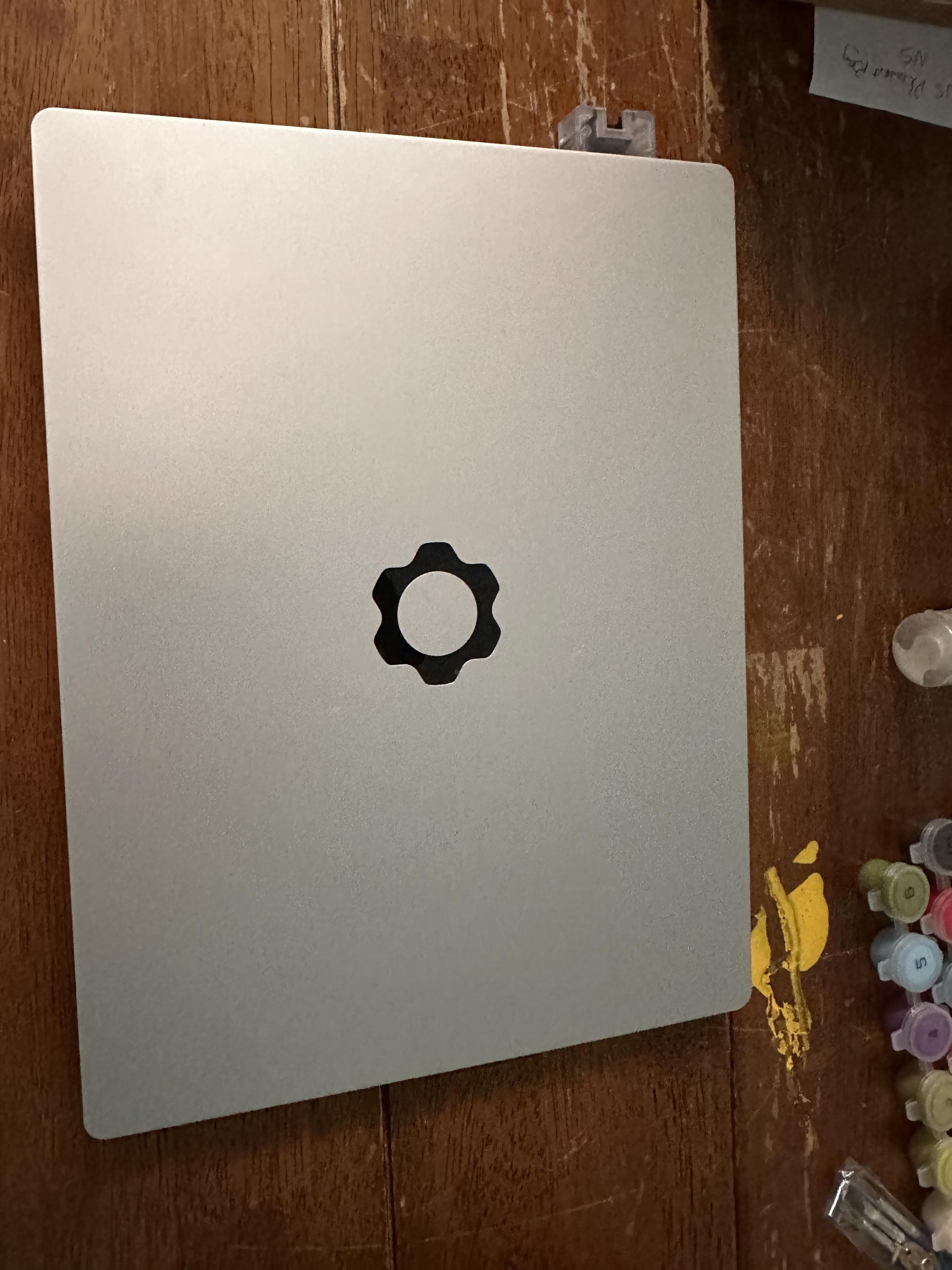 The completed framework 13 closed on a table so you can see the black gear logo clearly. 