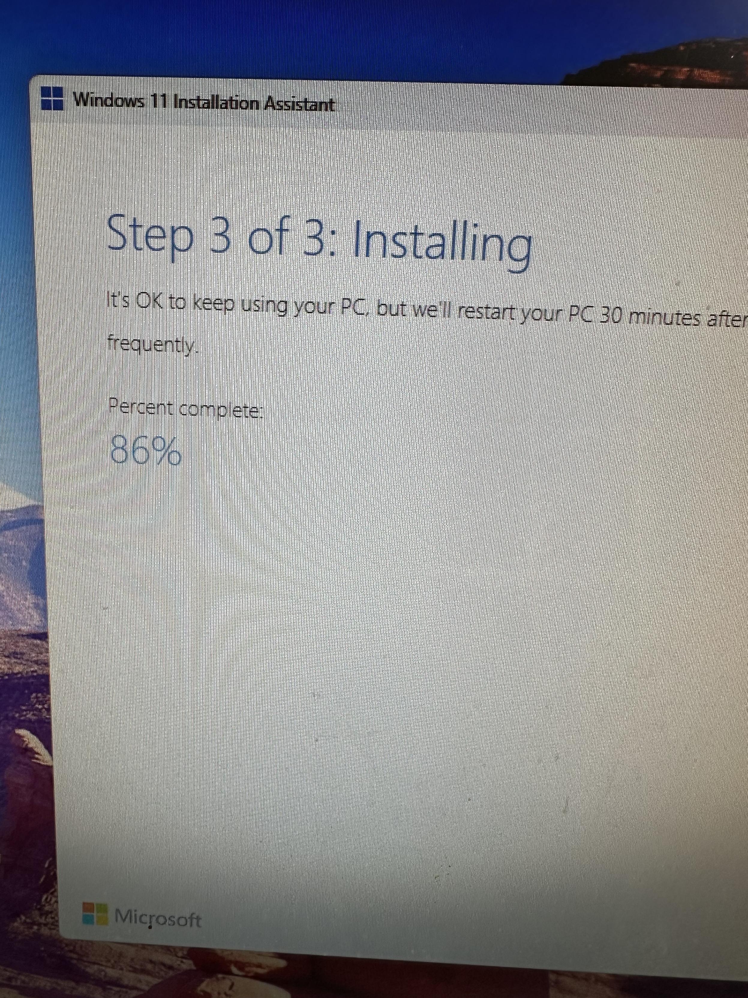 A photo of a PC monitor with the Windows 11 installer on Step 3 of 3, Installing. It’s at 86%. 