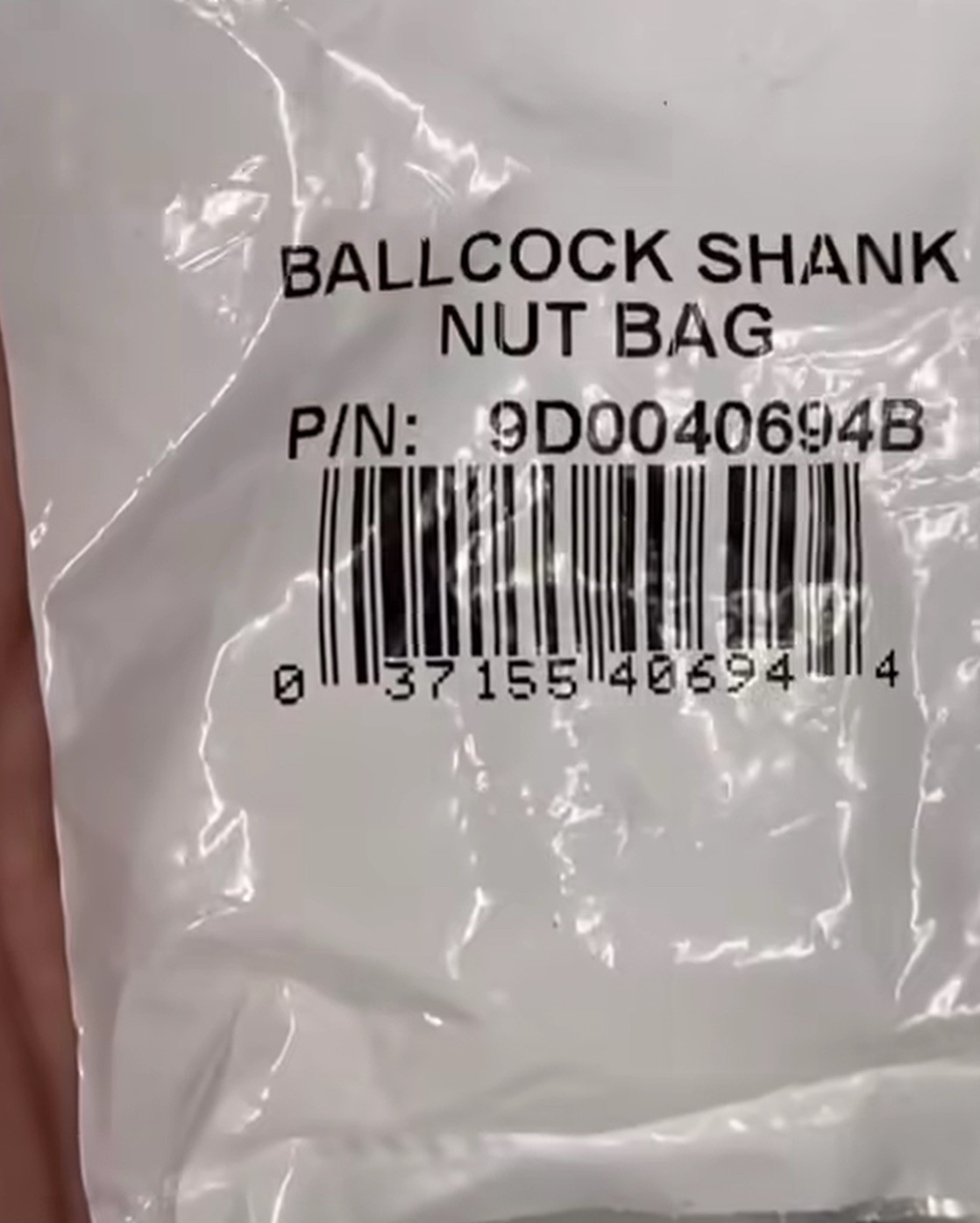 Photo of a white plastic bag with a UPC bar code. The text of the product name reads “BALLCOCK SHANK NUT BAG.”